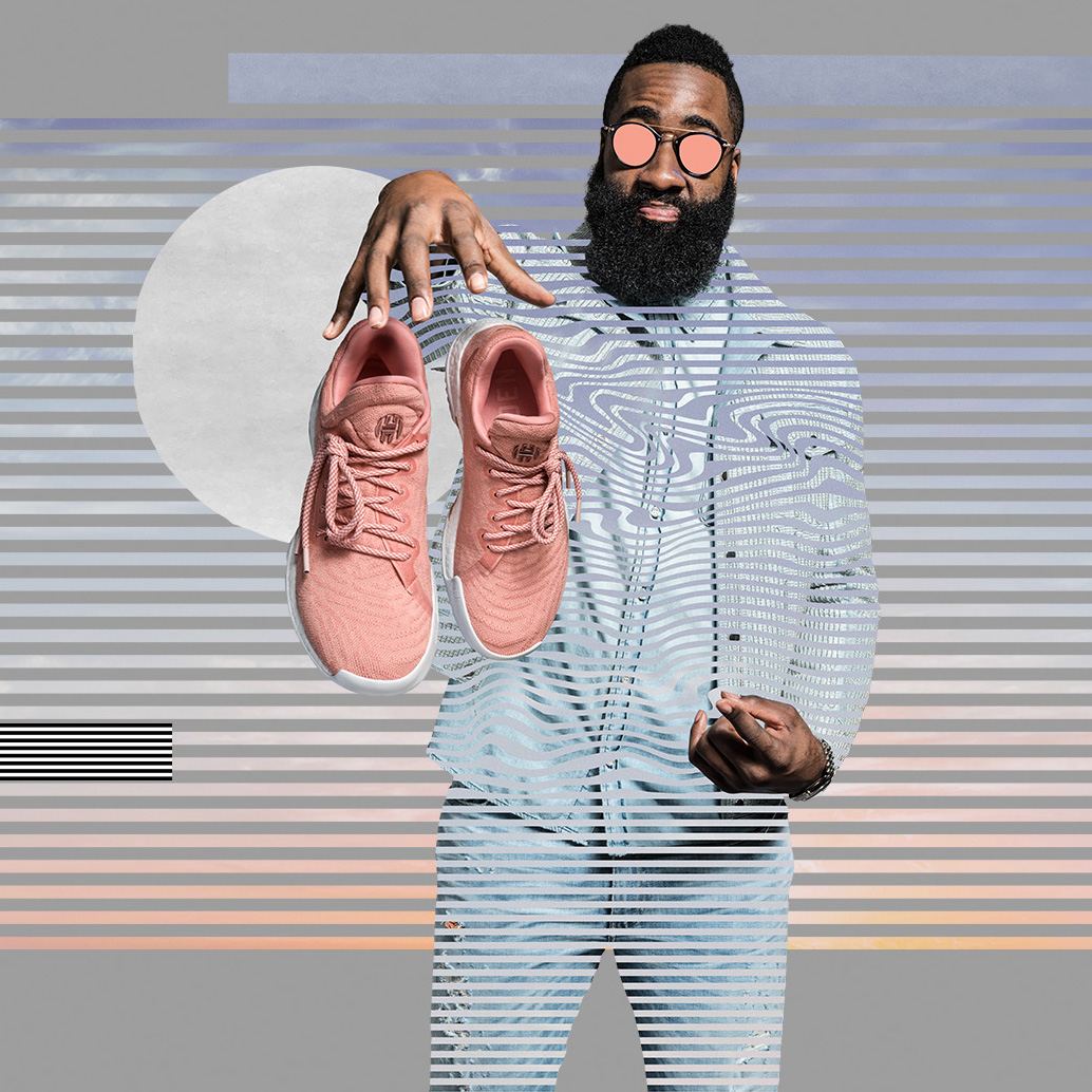 James Harden holding a pair of pink Harden LS in front of a striped backdrop.