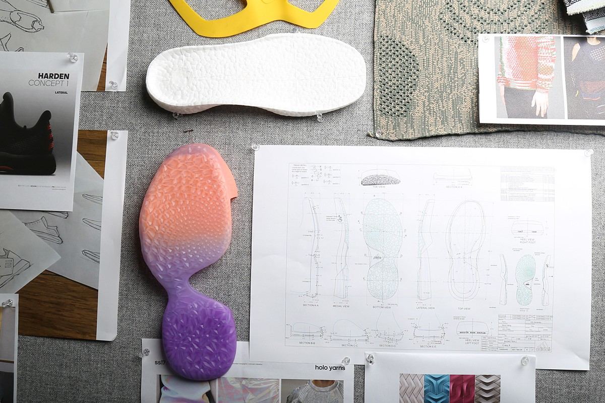 Design wall with molded outsole and midsole prototypes beside tech drawings and swatches.