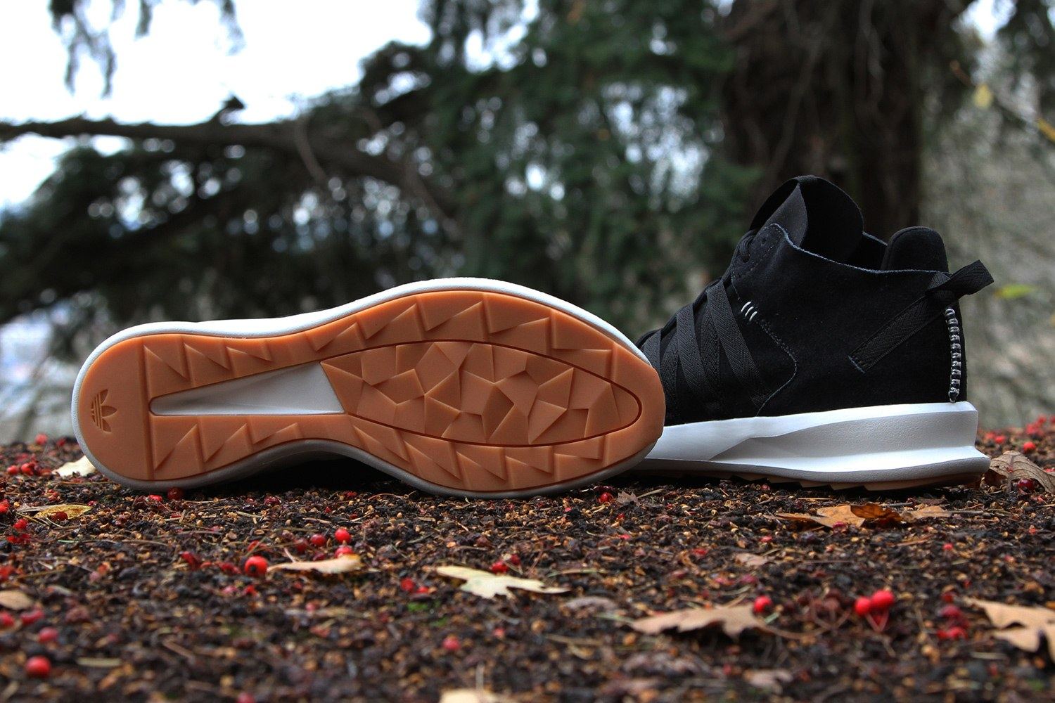 One shoe turned over to show the gum and white outsole, beside the other from the side.