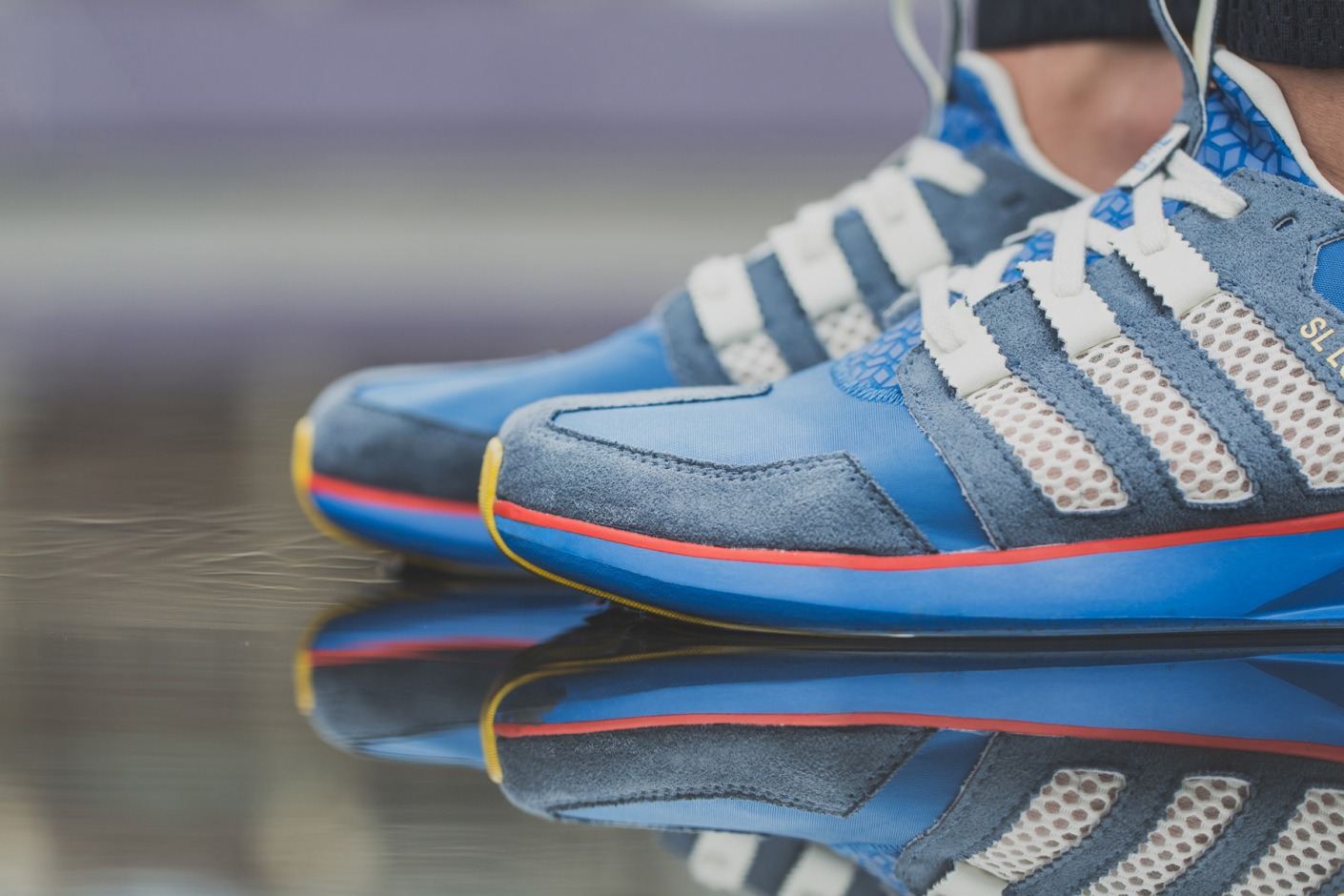 The blue suede pair from the toe, with a yellow and red midsole line.