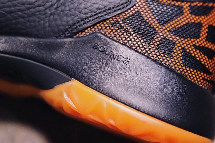 Close-up of the black heel counter debossed with Bounce above the orange outsole.
