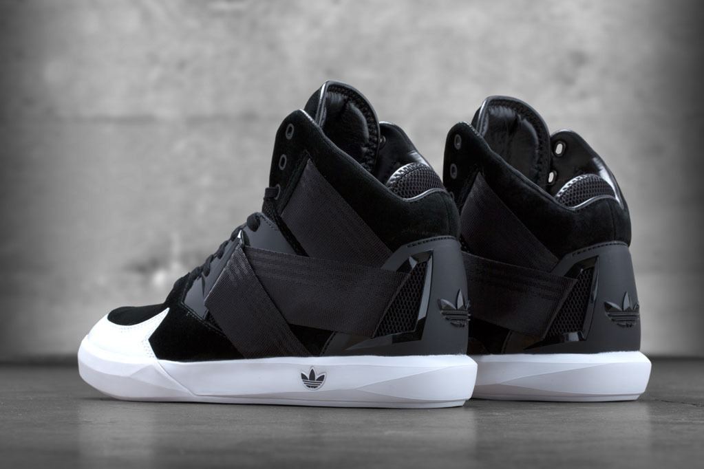 Heels of the black and white pair, with the black strap wrapping the grey heel counter.