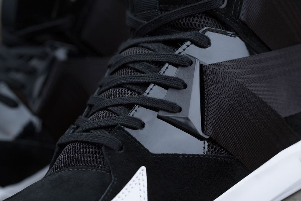 Close-up of the black laces, mesh and patent overlays at the forefoot.