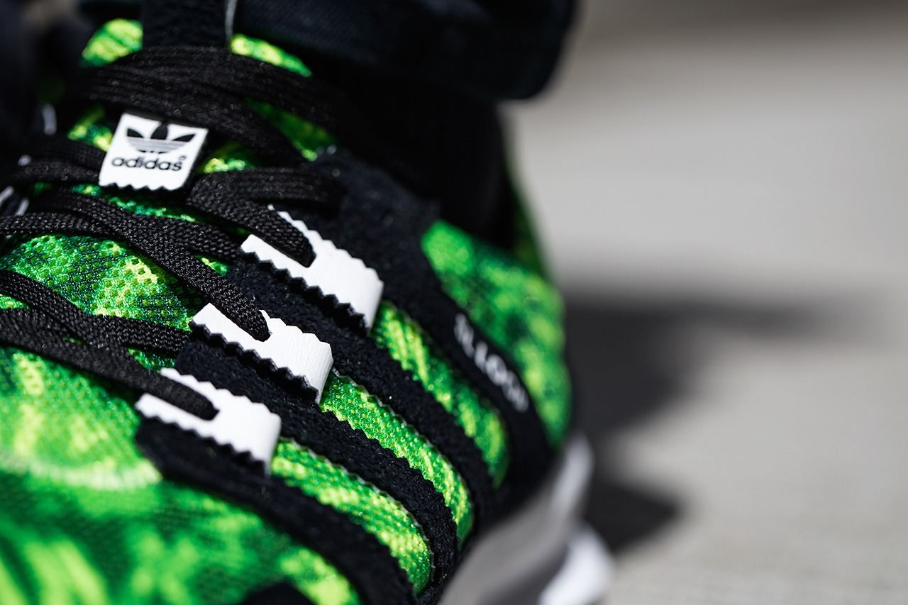 Close-up of the green palm print upper with black looped stripes and laces.