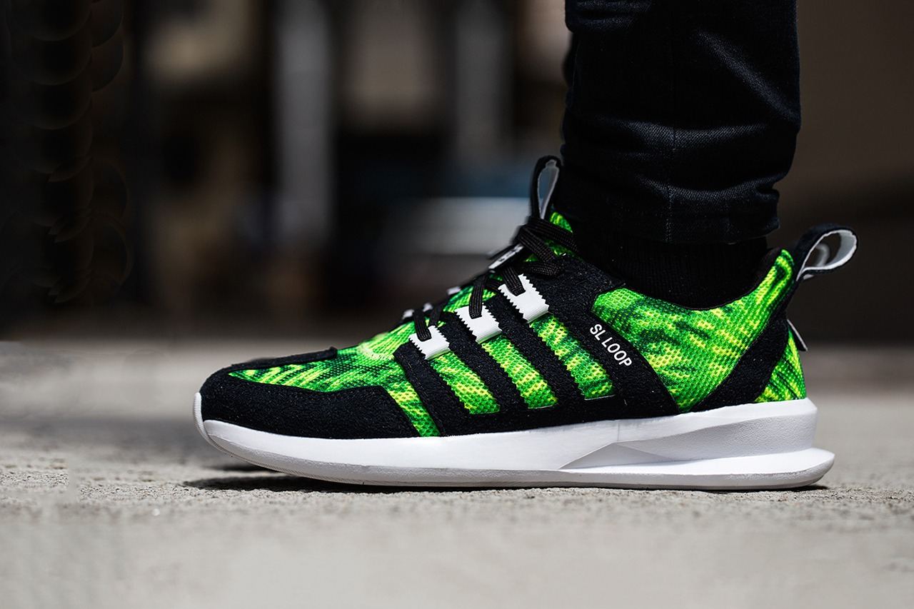SL Loop Runner in a black and green palm print with black stripes, worn, lateral view on pavement.
