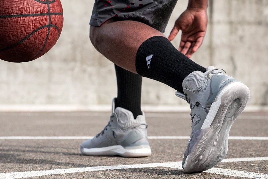 The grey D Rose 7 on foot, crossing over on an outdoor court.