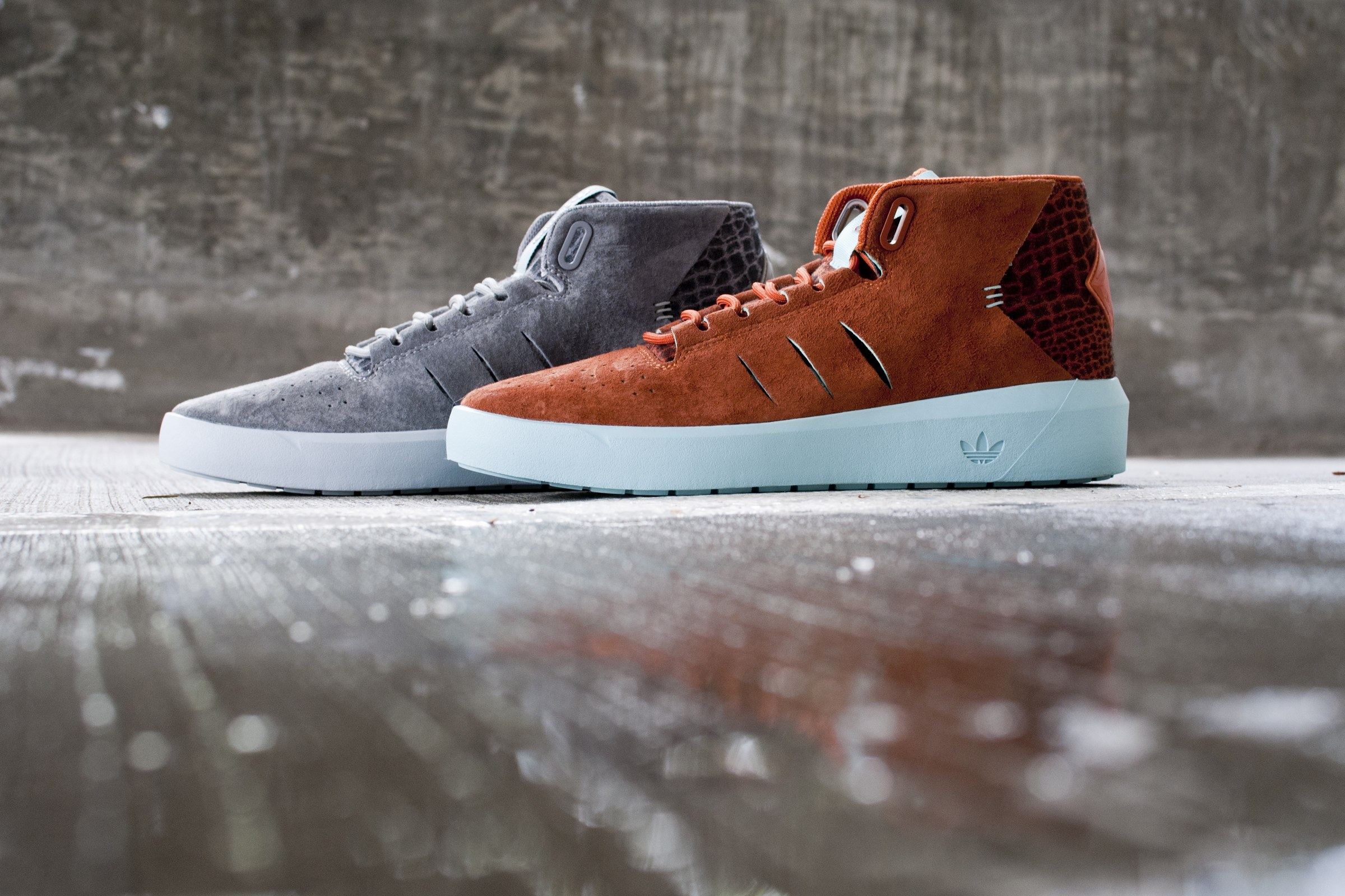 The Northrup in grey and rust suede side by side on wet concrete, on icy blue soles.