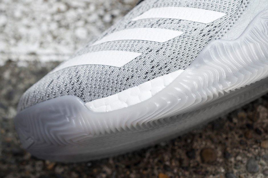 Close-up of the grey knit forefoot with white stripes and a translucent outsole.
