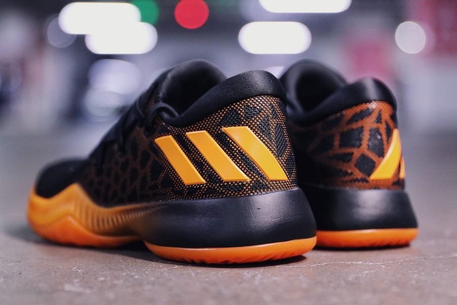 Heels of the black and orange Harden BTE pair, showing the orange stripes and the black heel counter.
