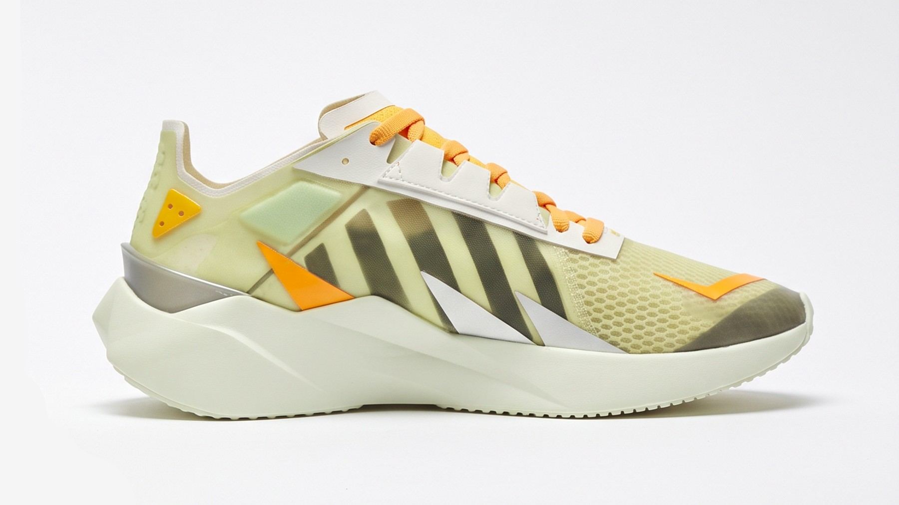 The finished shoe in pale yellow mesh with black stripes, orange laces and accents, and an off-white midsole, medial view.