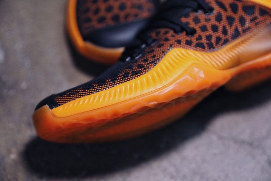 Close-up of the forefoot and the sculpted translucent orange outsole edge.