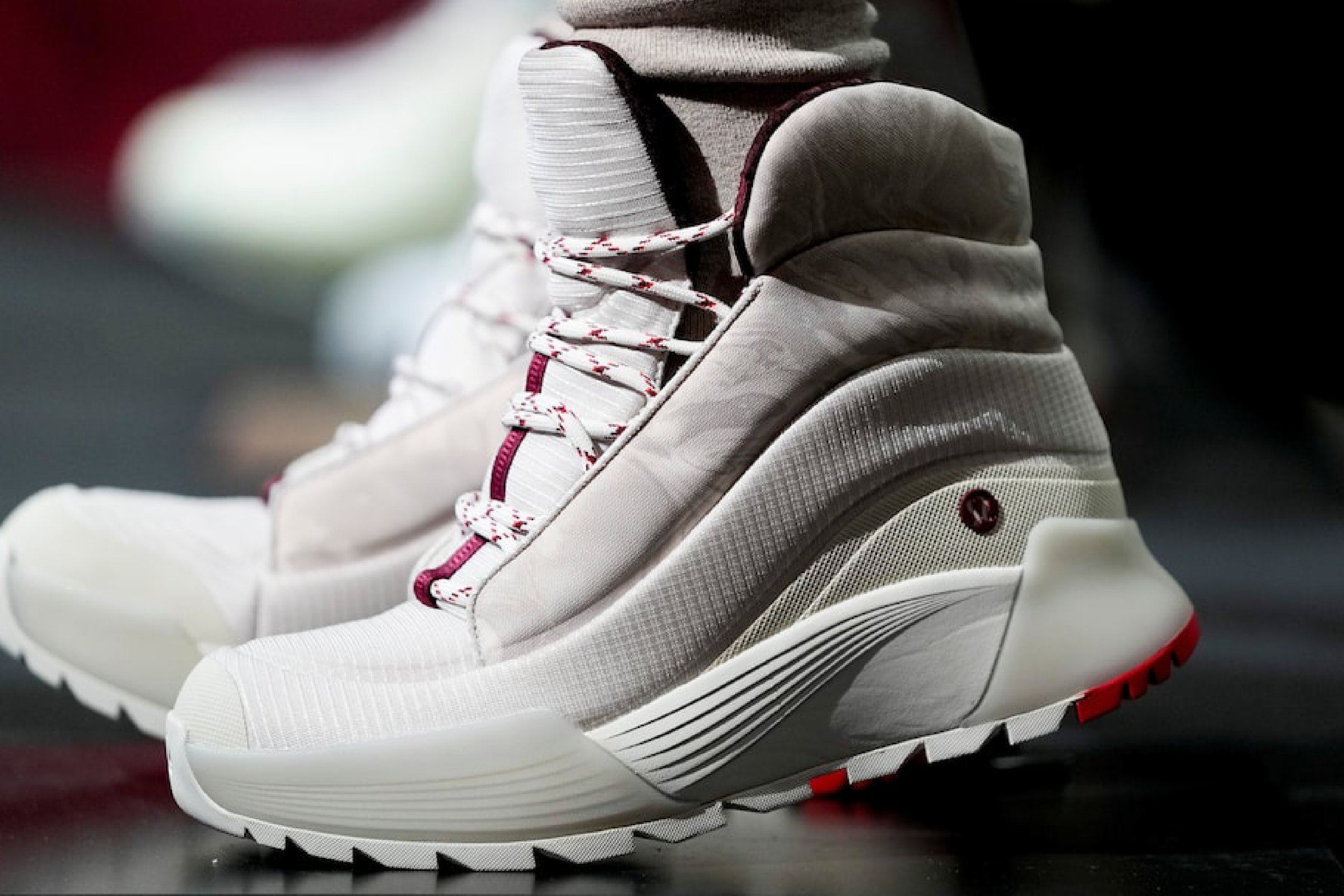 Close-up of the cream boot on foot, with a striped rope lace, translucent midsole wrap, and sawtooth lugs.