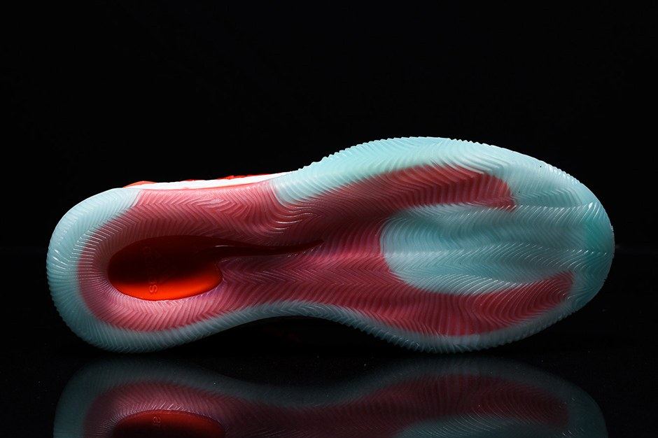 The orange colorway outsole on black, translucent aqua at the heel and forefoot.
