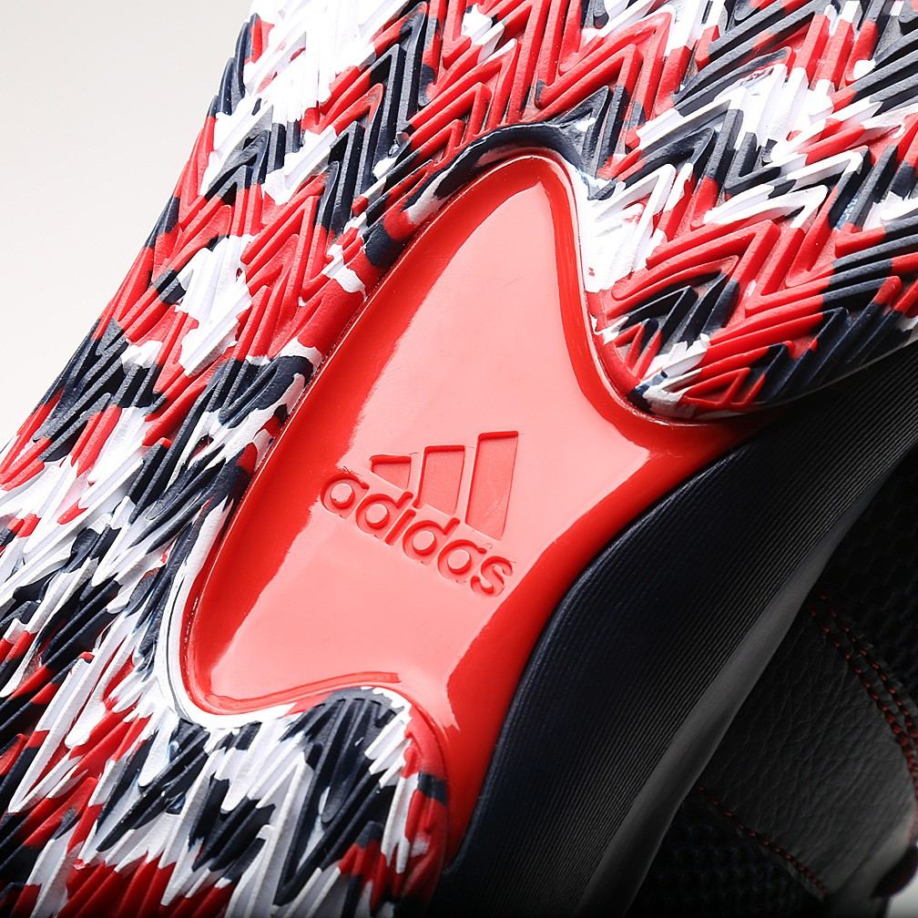 Close-up of the outsole with a red adidas logo window set into red, white, and navy camo rubber.