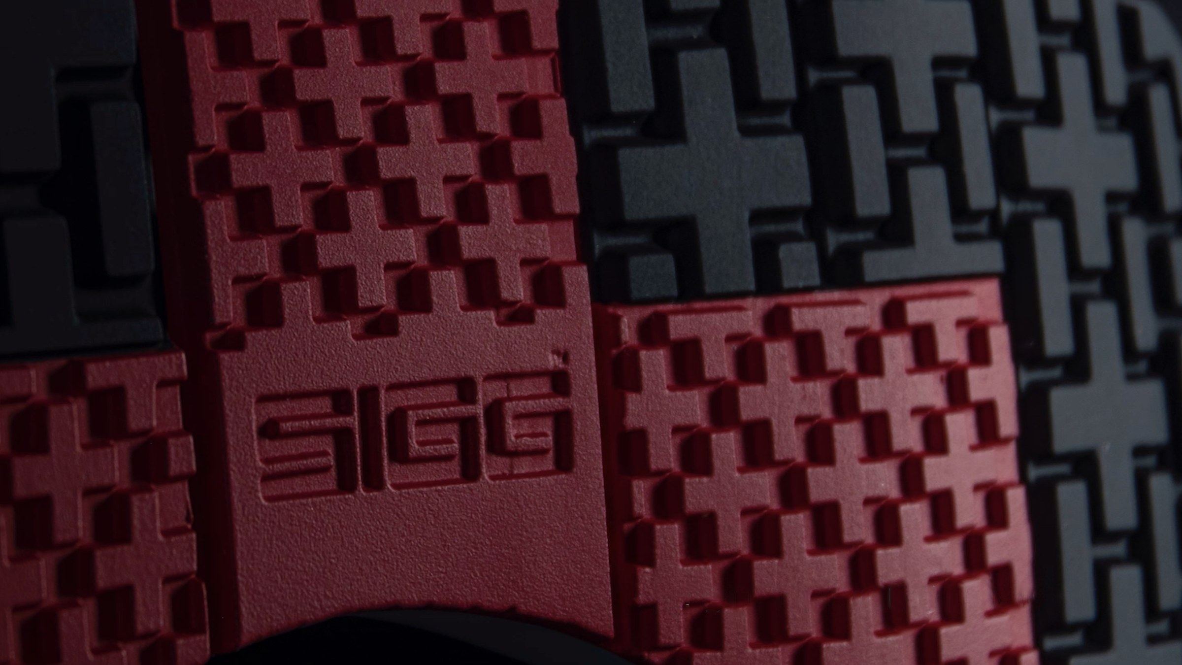 Close-up of a red and grey outsole with Swiss cross lugs and a SIGG wordmark.