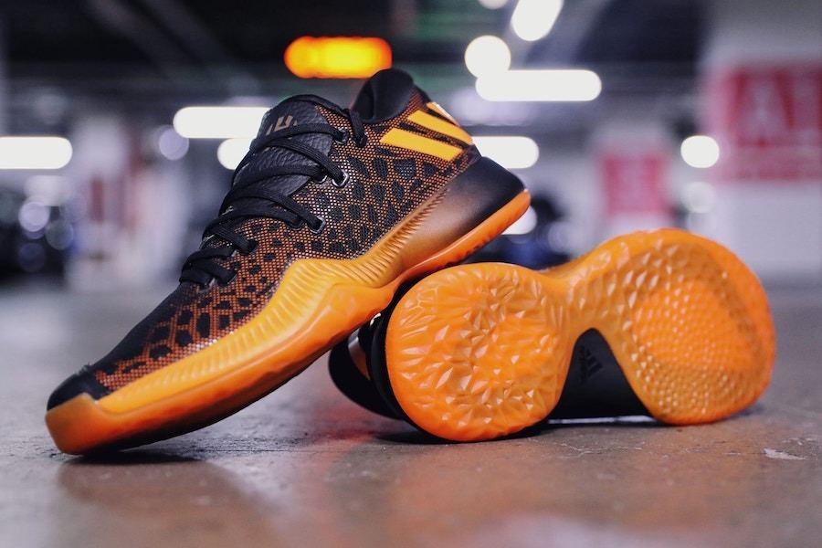 Harden BTE pair with one shoe turned over to show the translucent orange outsole and its traction pattern.