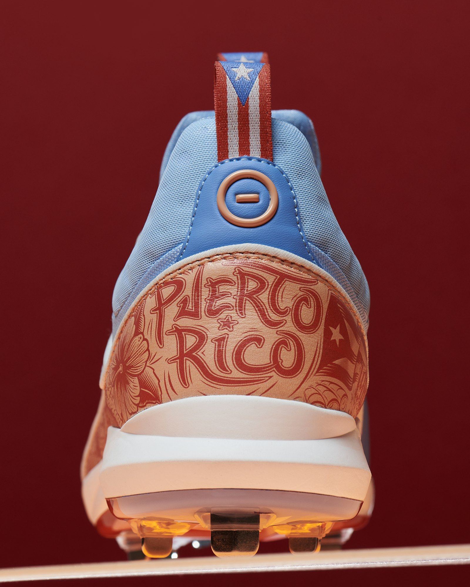 Heel of the Puerto Rico Zero, Puerto Rico lettering and hibiscus print in coral above a flag pull tab, on deep red.
