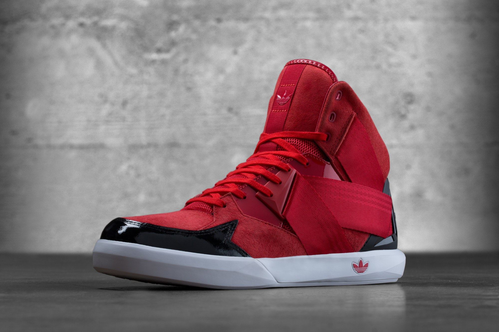 The red C-10 in suede with a red strap and black patent toe, three-quarter view from the front.
