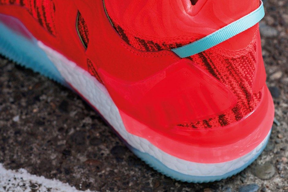Close-up of the red heel counter with an aqua pull loop over Boost cushioning.