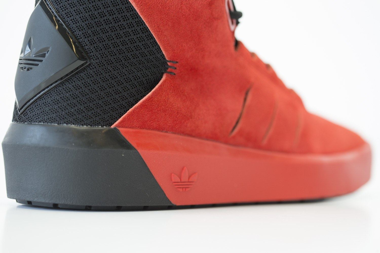 Close-up of the heel, where the black wrap meets the red cupsole with a debossed Trefoil.