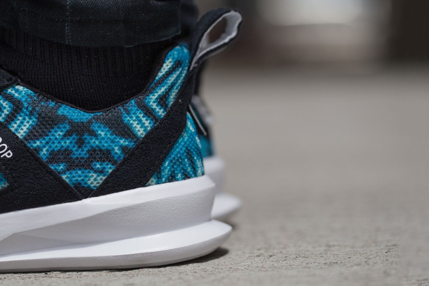 Close-up of the teal palm print heel and white midsole.