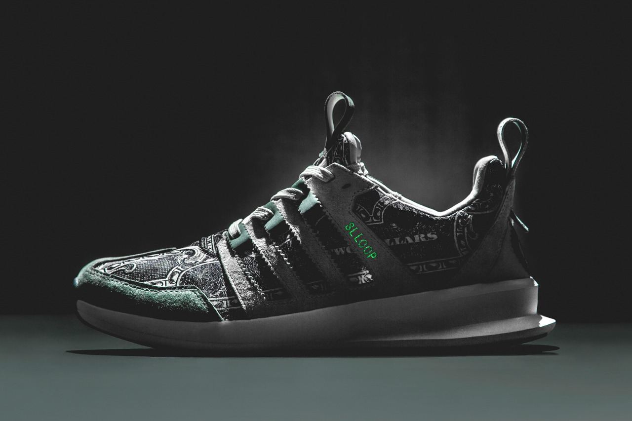 The Wish Independent Currency SL Loop Runner with a banknote-print upper on a dark backdrop, lateral view.