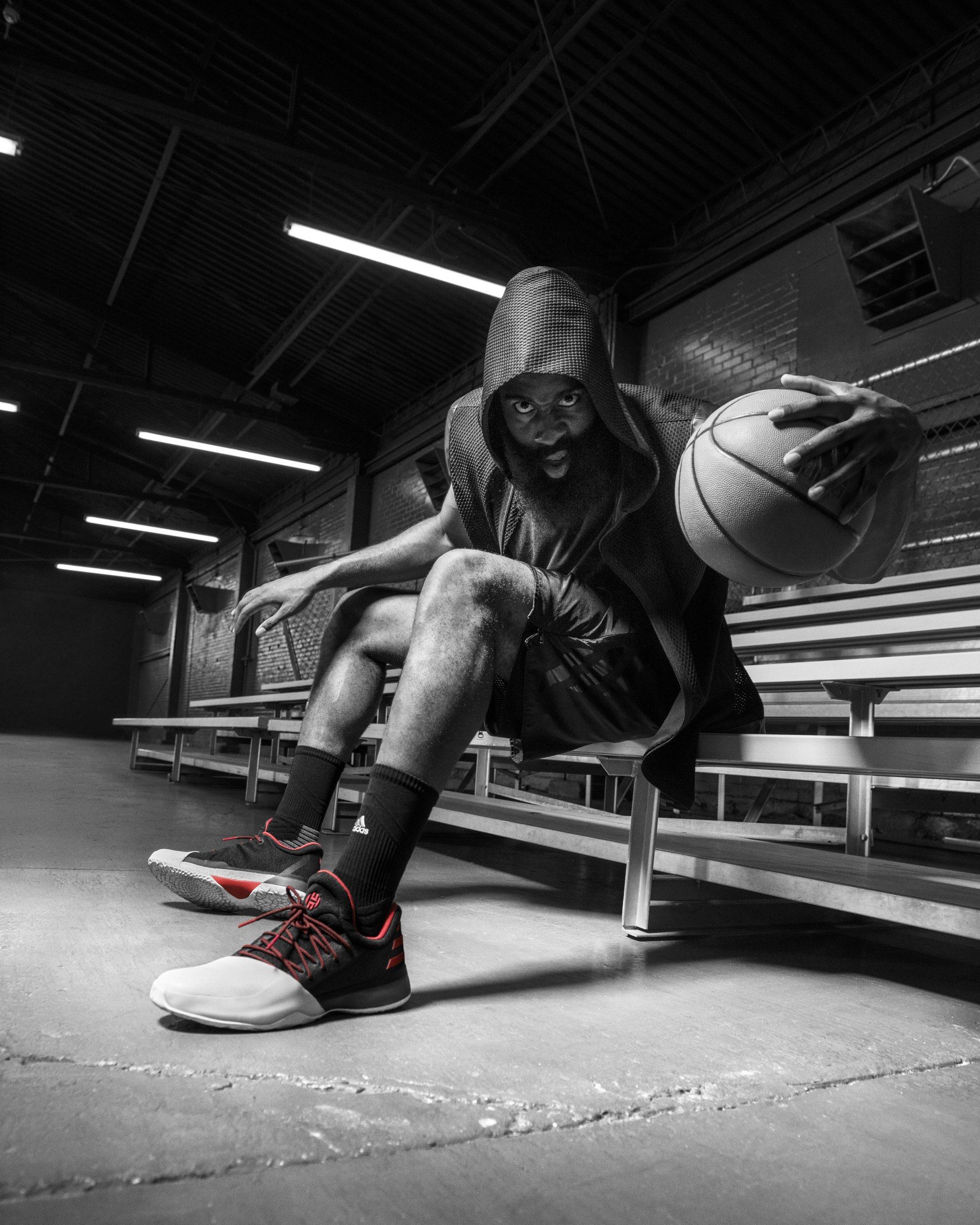 Black-and-white photo of a player seated on bleachers wearing the Harden Vol. 1.