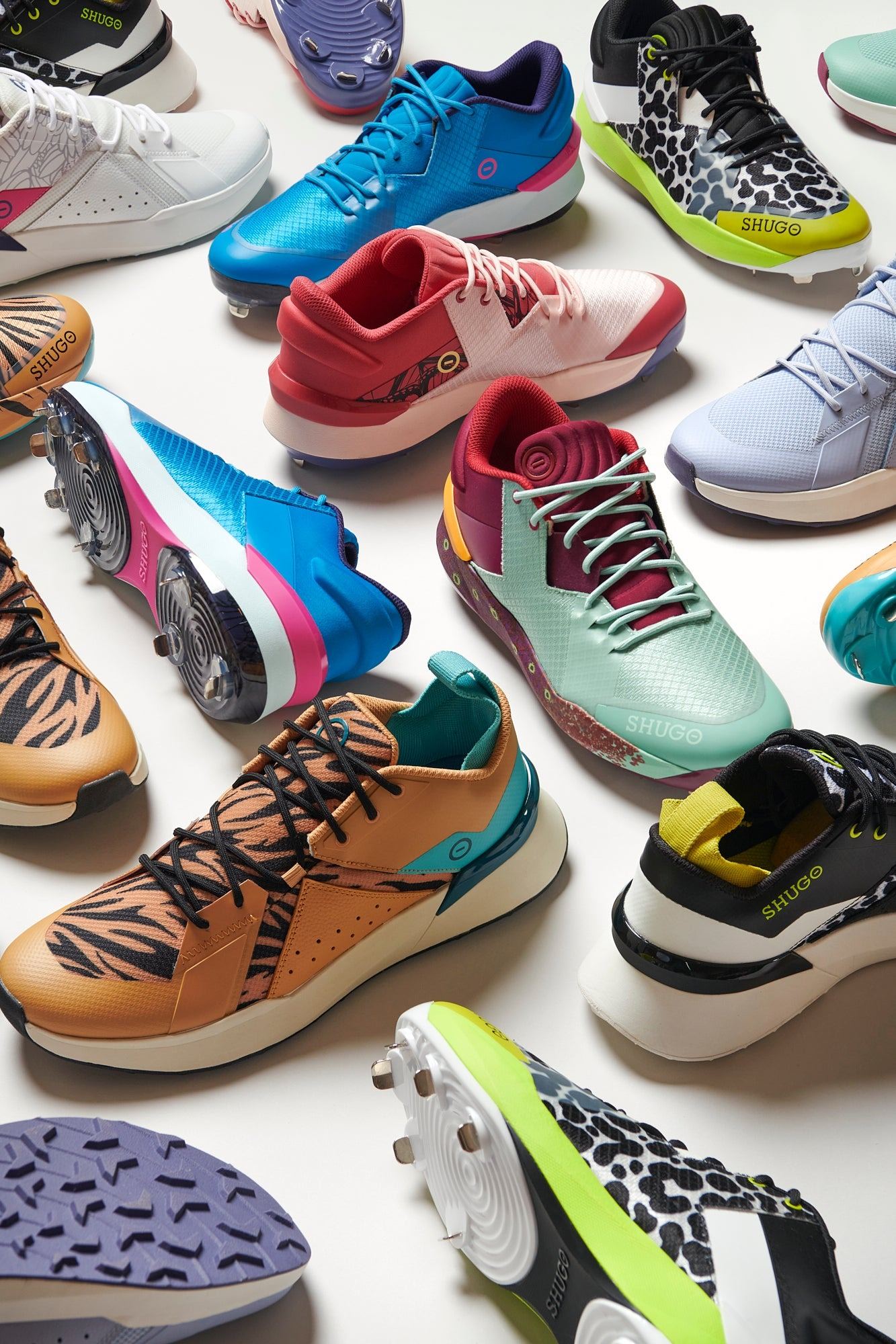 The Stealth in Nature collection, KAI 2 cleats and ZEN 2 trainers in tiger, eel, butterfly, squid, and hummingbird colorways scattered across a white floor.